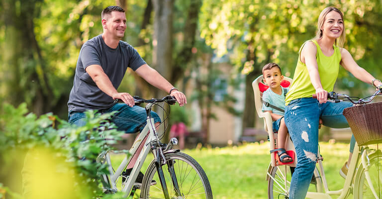 Família feliz de bike no parque